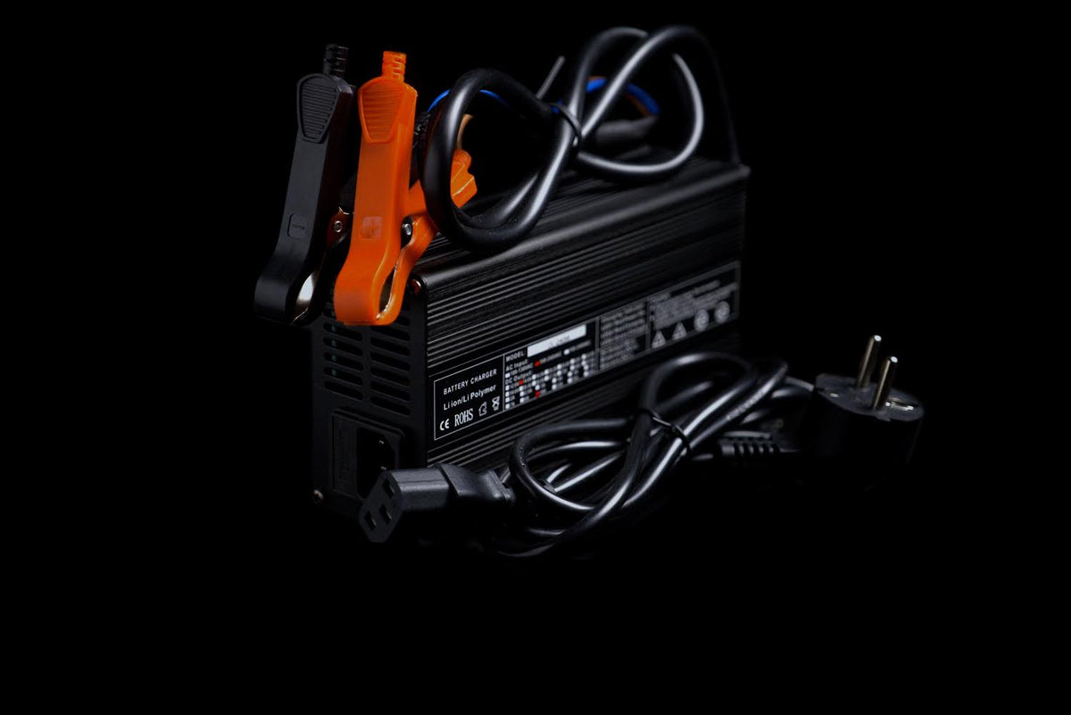 Batterie LiFePO4 12,8 V avec bornes orange et câbles, vue de dessus