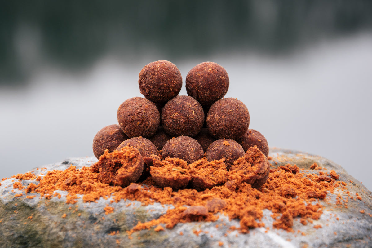 Bouillettes d’appâts orange-brun en petites billes, au sommet d’un tas