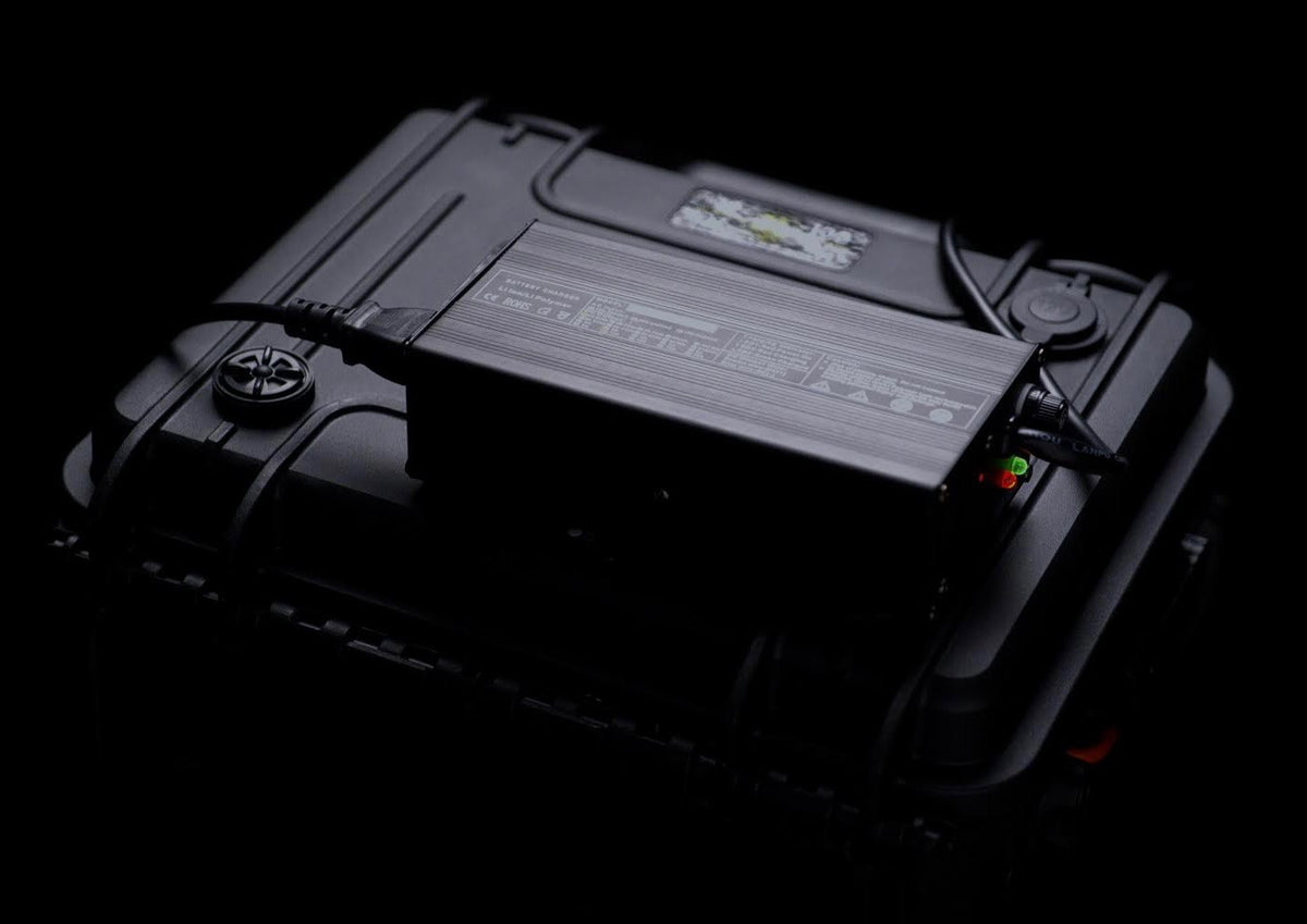 Batterie LiFePO4 12,8 V noire avec étiquette, voyants et connecteurs sur le côté