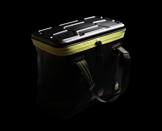 Sac étanche noir à coque rigide, poignée sur le dessus, bordure jaune-vert.